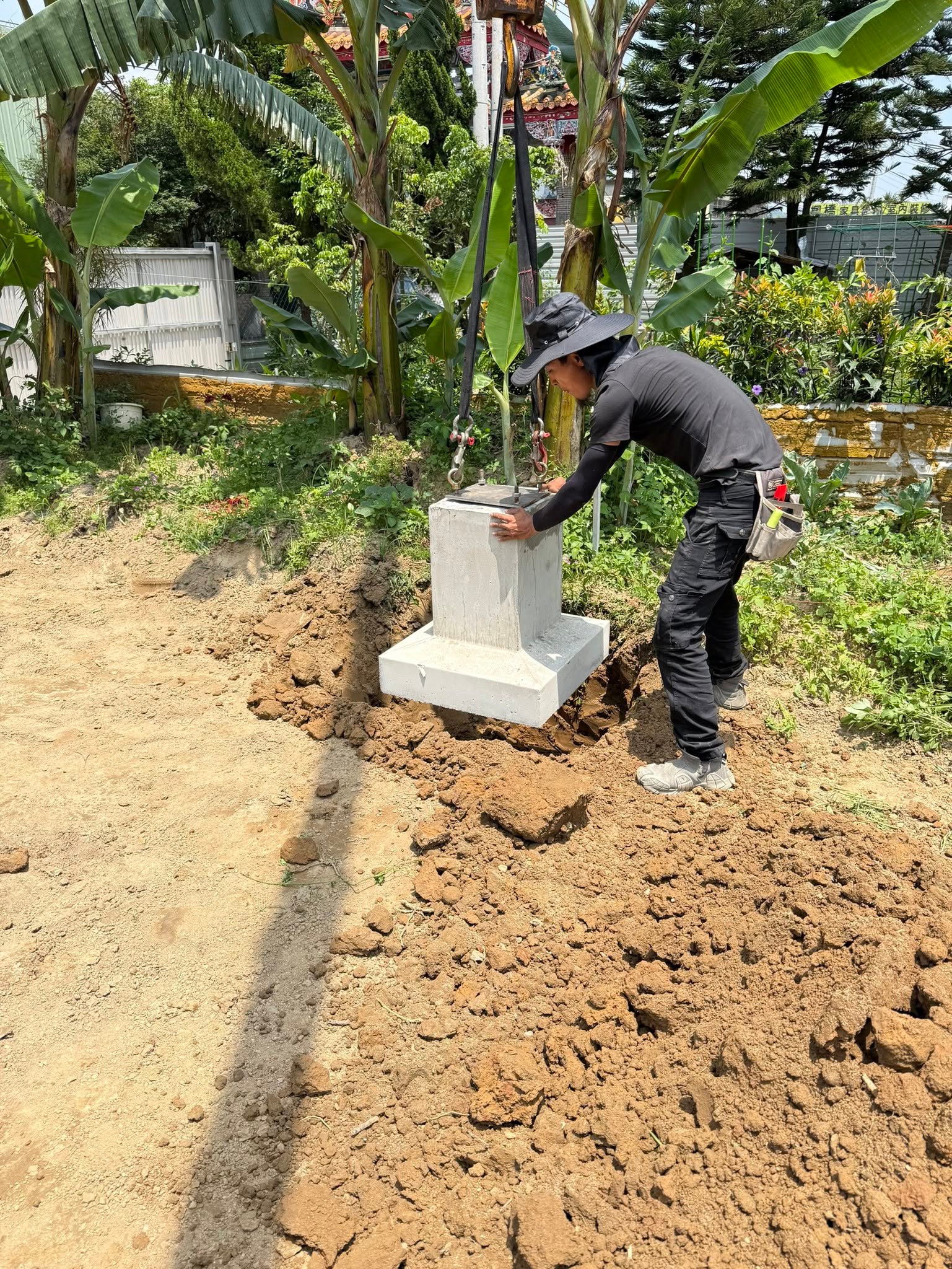 吊運就位：照片呈現預鑄基礎吊運至開挖位置的現場作業情境。
